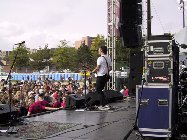 Man playing guitar and singing at outdoor music festival